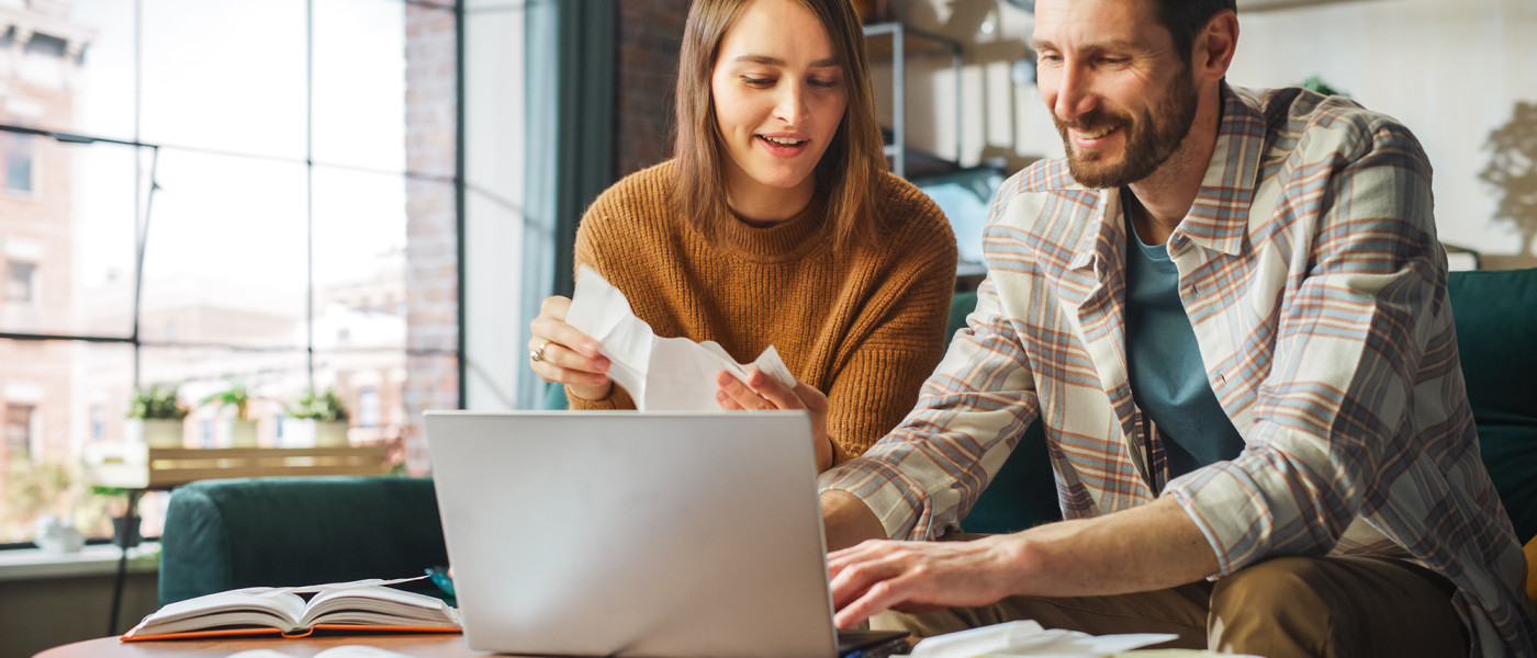 Couple assis côté à côte discutant projets Epargne budget assurance vie etc