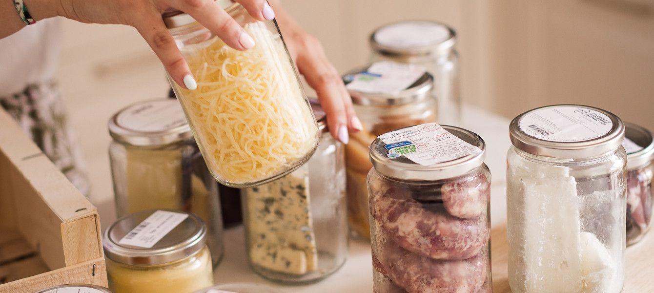 Woman's hand reach for mason jars full of delicious products