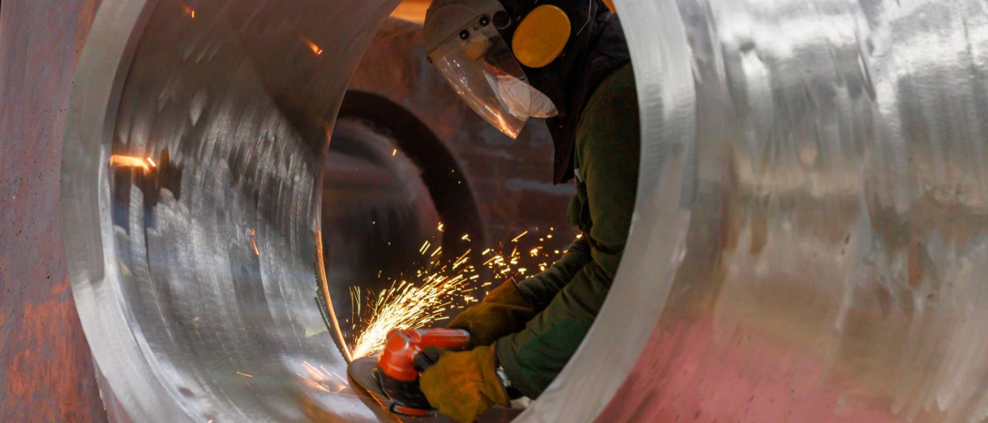 Un ouvrier traite la buse du récipient du réacteur avec un équipement spécial.