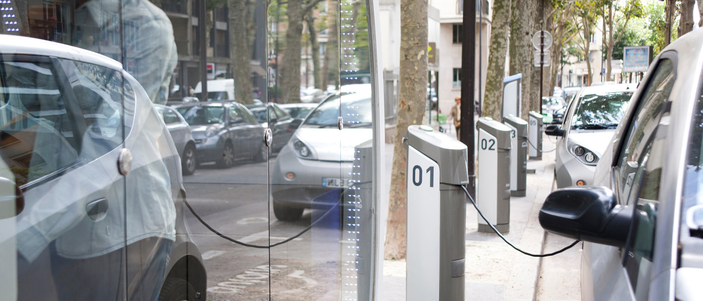 woman who rents an electric car in the city where a row of charging stations