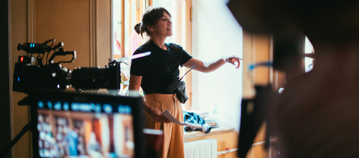 Female director of photography with a camera on a movie set. Professional videographer on the set of a movie