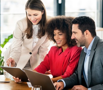 Smiling male and female professionals working on tablets in office