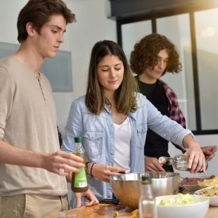 Flatmates cooking together at home.