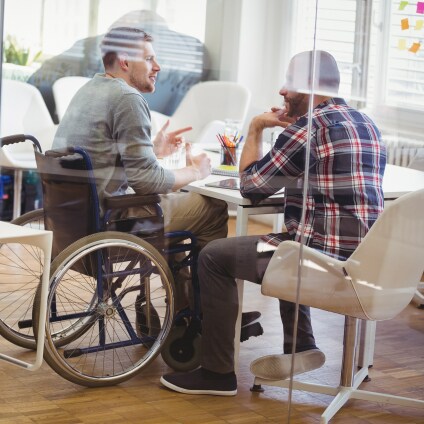 Homme en fauteuil roulant en réunion avec un collègue