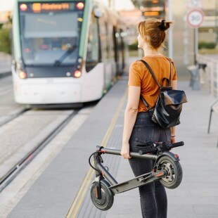 Mobility of the future femme avec scooter plié qui attend le tram mobilité urbaine