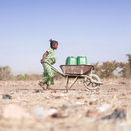 Little African Woman Transporting Fresh Water as a drought symbol