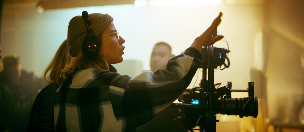 A female director at work on the set. The director works with a band or with a speaker during the filming of a movie, commercial, or television series