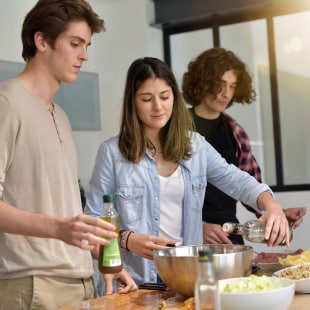 Colocataires cuisinant ensemble à la maison.