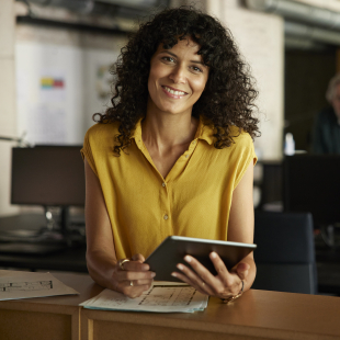 Femme souriante tenant une tablette dans un bureau