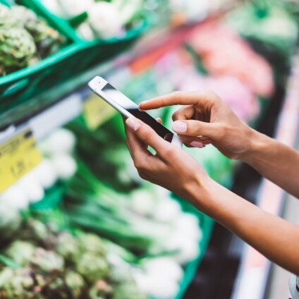 Femme avec telephone mobile pour choisir les aliments