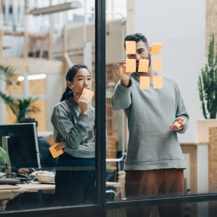 Two people working post-it glass
