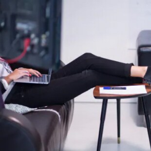 Femmes avec un ordinateur assiste avec les pieds sur une table