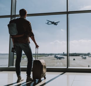 Homme à l'aeroport qui regard des avions qui atterrissent sur le tarmac