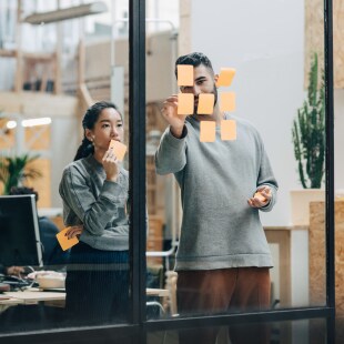 Deux personnes travaillant post-it vitre