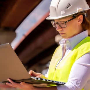 Femme ingénieur avec ordinateur et sous un pont