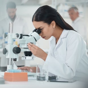 Femme devant un microscope dans un laboratoire de recherche
