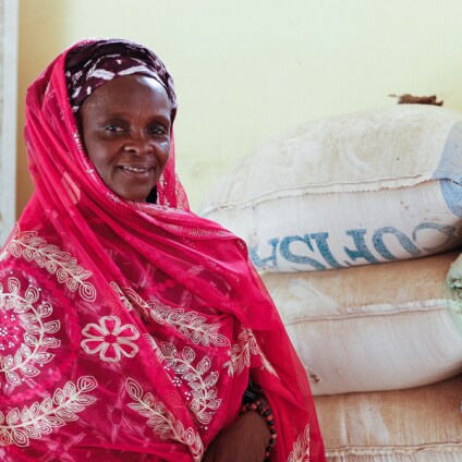 African woman in front of bags of rice