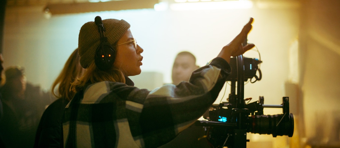A female director at work on the set. The director works with a band or with a speaker during the filming of a movie, commercial, or television series