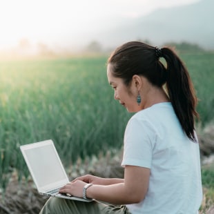 Jeune femme, chercheuse scientifique, dans un champ d'oignons avec un ordinateur
