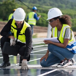 Des ingénieurs homme et femme qui font l'inspection de l'installation de panneaux photovoltaiques