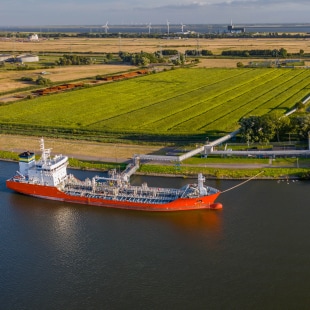 Navir amarré à un point de stockage hydrogène avec eoliennes en fond