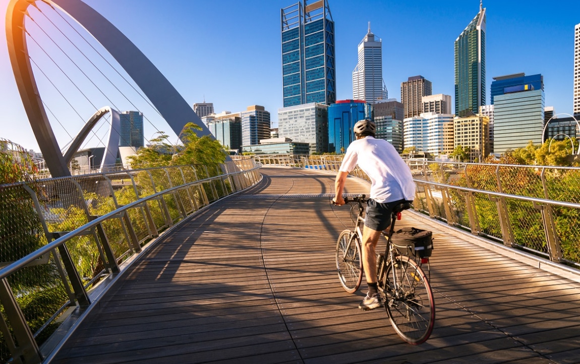 Un homme à vélo sur un pont et des immeubles en arrière-plan