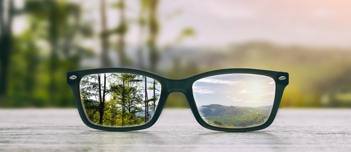 glasses whowing a different point of view of a mountain and a forest