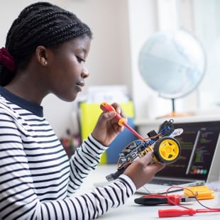 Female Teenage Pupil Building Robot Car In Science Lesson
