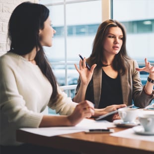 Modern three female colleagues brainstorming about work