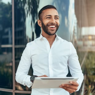 Jeune homme souriant avec une tablette