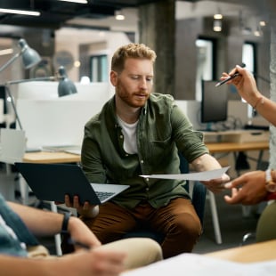 Team of young entrepreneurs working on new business project during meeting in the office.