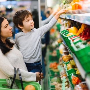 A mum and her child choose fruit and vegetables in the supermarket