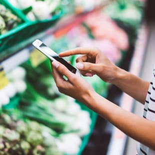 Femme avec telephone mobile pour choisir les aliments