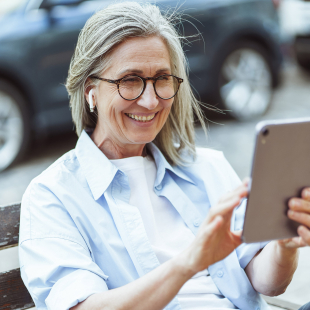 Happy senior lady enjoying a content on a tablet