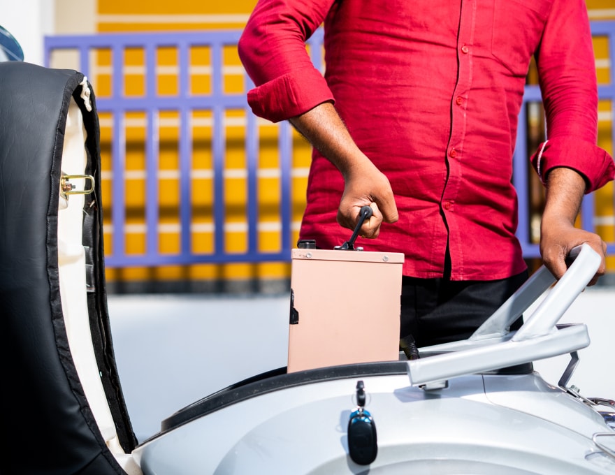 Homme remplaçant une batterie dans un scooter électrique / Mobilité durable