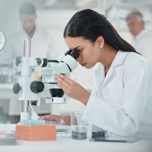 Femme devant un microscope dans un laboratoire de recherche